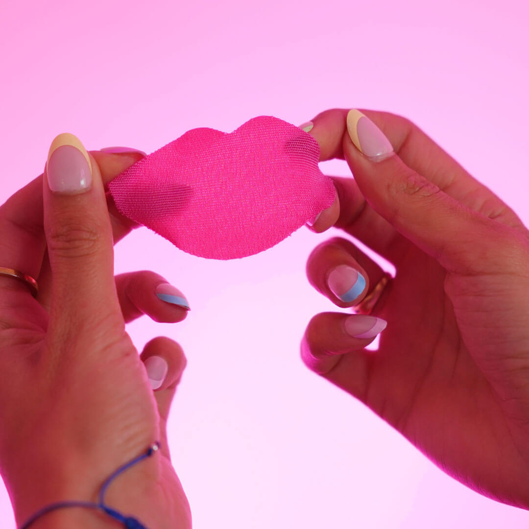 Hands holding Goodnight Tape pink lip mouth tape